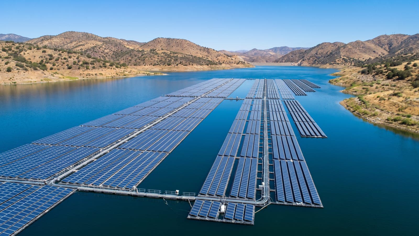 Vista aérea de una planta solar fotovoltaica flotante sobre un embalse en España a pleno mediodía