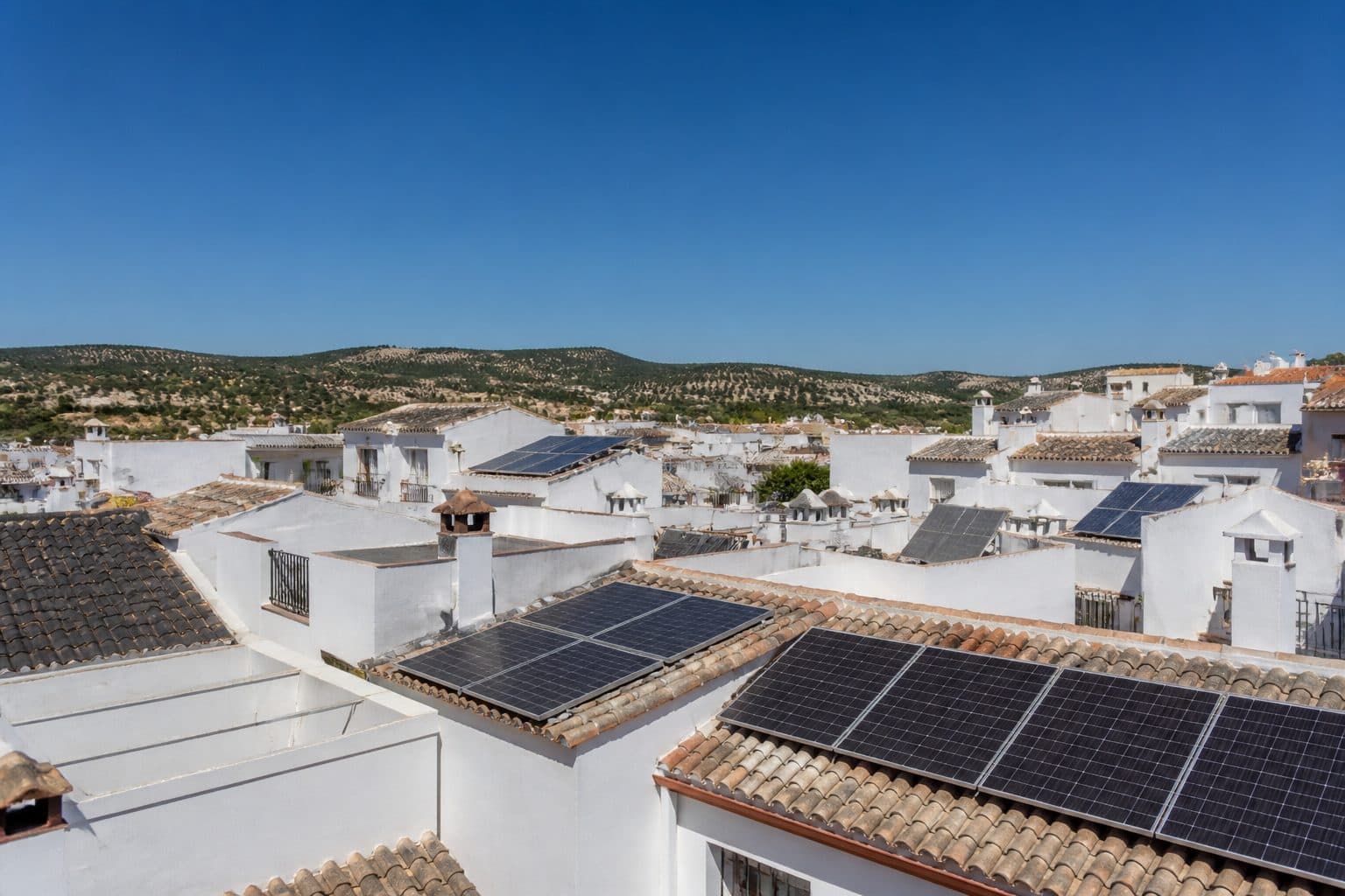 Tejado con placas solares y antena sobre barrio andaluz
