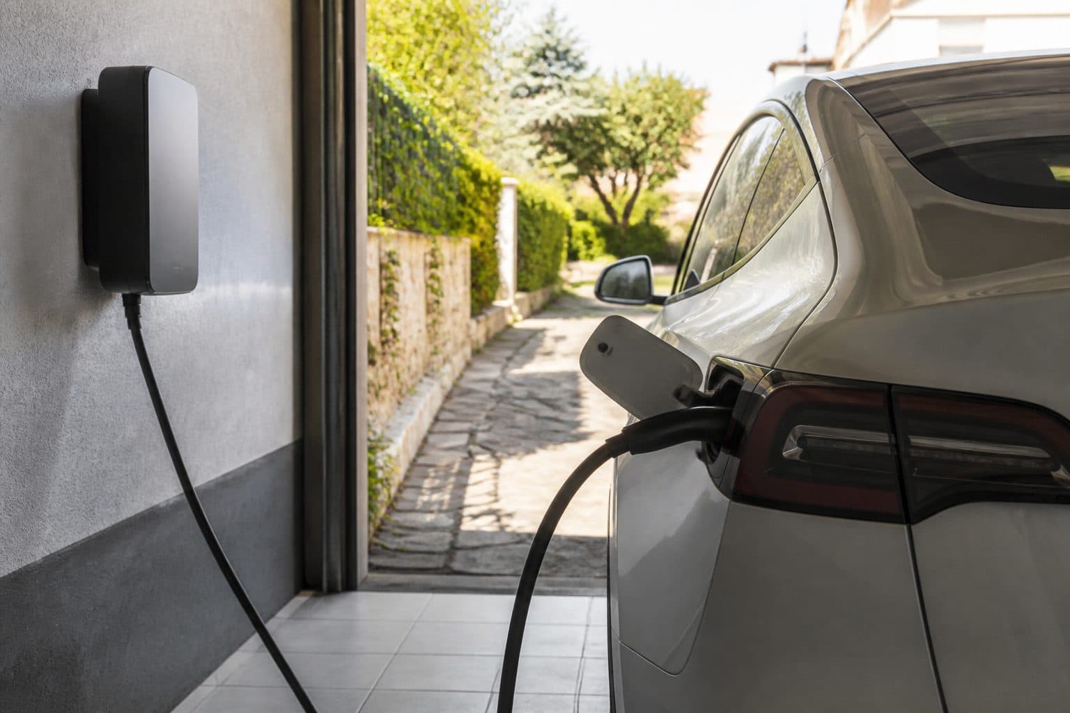 Coche eléctrico cargando en garaje residencial a mediodía