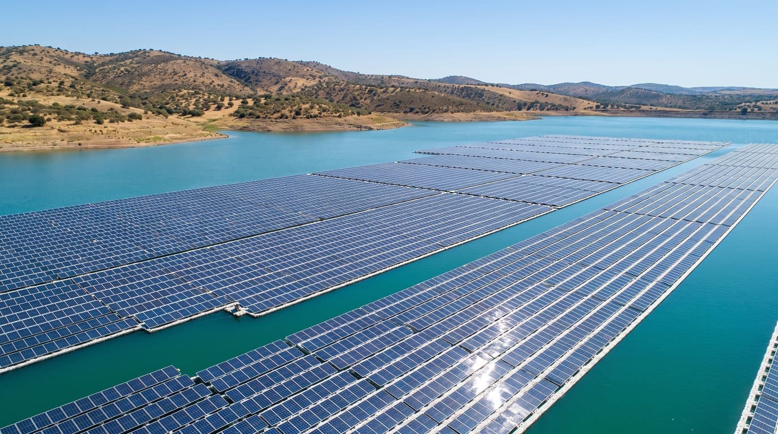 Vista aérea de una planta solar fotovoltaica flotante sobre un embalse en España a mediodía